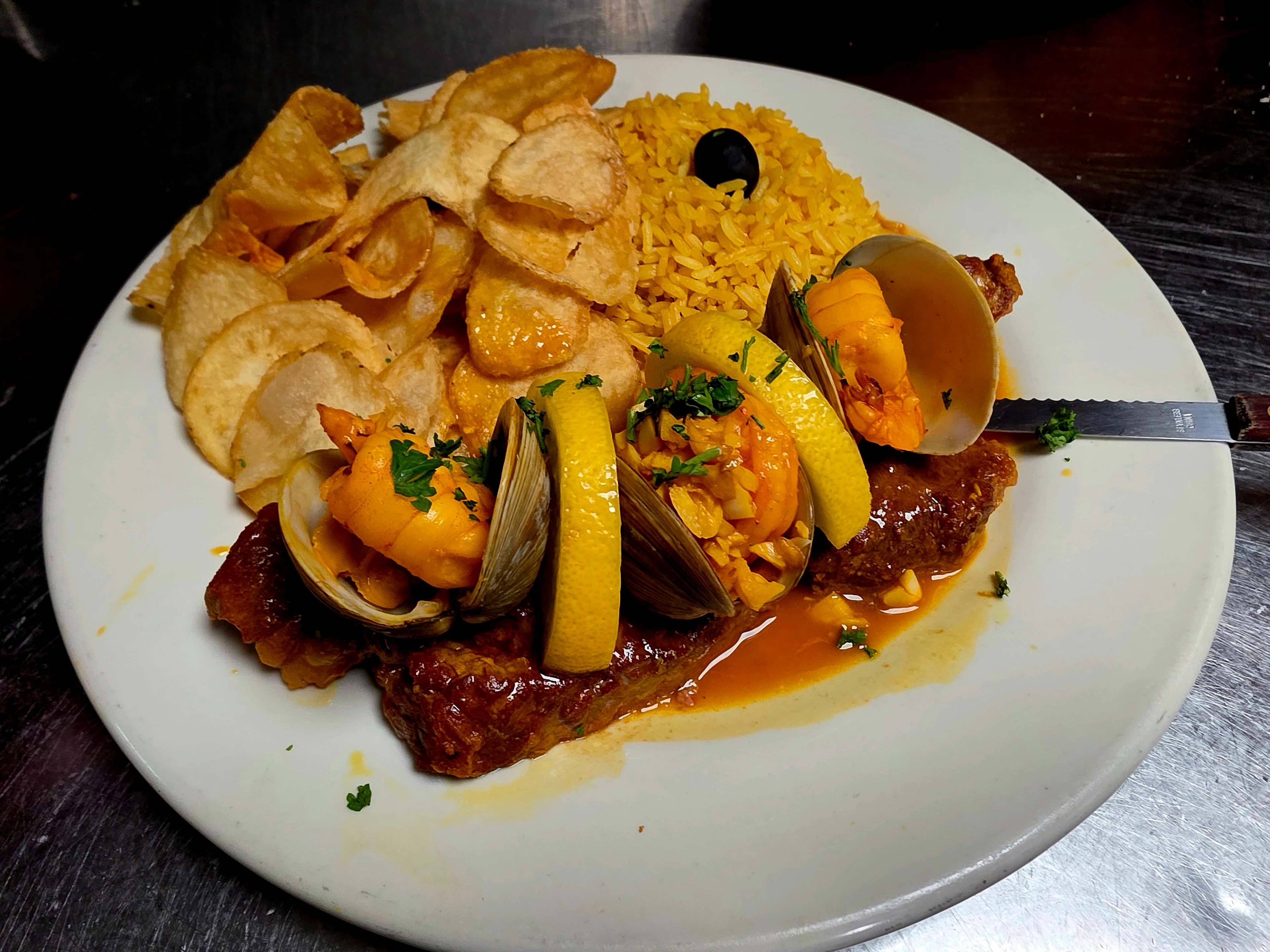 Grilled shrimp served on a terracotta plate with lemon